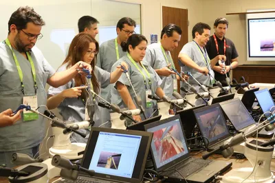 Professionals performing laparoscopic simulations in a Nicholson Center Lab Boardroom.