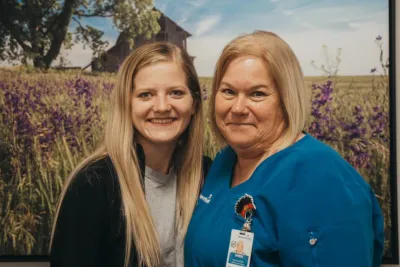 ottawa two nurses standing in front of flower picture