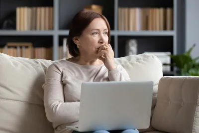 A woman thinking while on her laptop