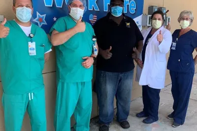Physicians wearing masks give thumbs up