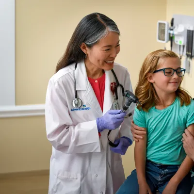 A Physician Smiles at Her Patient's Mother as They Wrap up Her Doctor's Visit