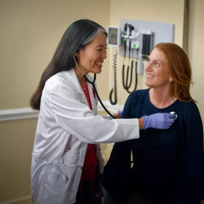 A Provider Checks Her Patient's Vitals in an Exam Room