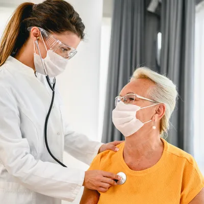 A doctor listens to a patient's breathing with a stethoscope