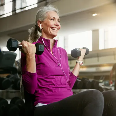 A Senior Woman Works Out at the Gym with a Smile on Her Face