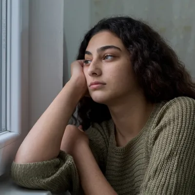 A Woman Stares Longingly Out a Window