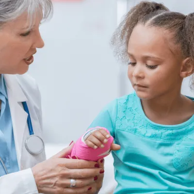 A Doctor Check's a Little Girl's New Cast