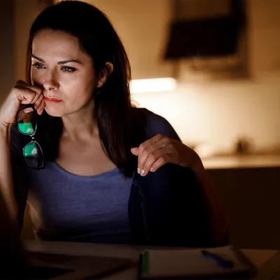 An adult woman focused on her computer