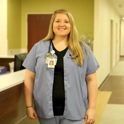 A white woman standing in a hall at the hospital 