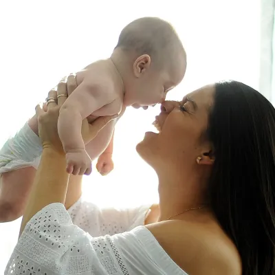 A mother holds her baby up.