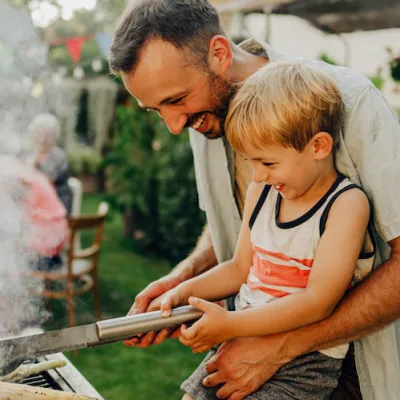 father son grill corn on the barbeque grill summer time