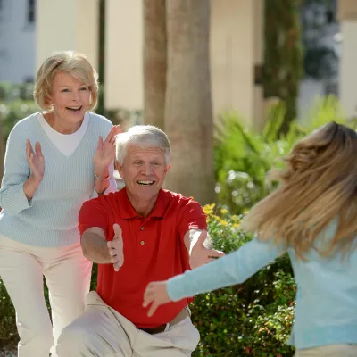 A girl sees her grandparents for the first time and runs to hug them. 