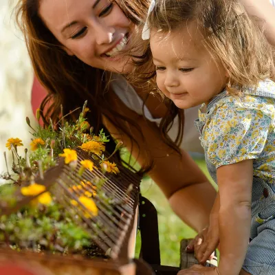 Mother and daughter smelling flowers.