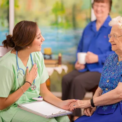 Nurse talking to mother and daughter.