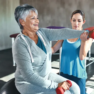 A woman lifts weights to help improve bone density and fight osteoporosis
