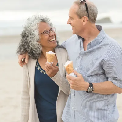 A couple enjoys a walk on the beach together.
