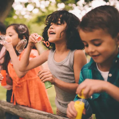 A group happy children blowing bubbles during the summer.