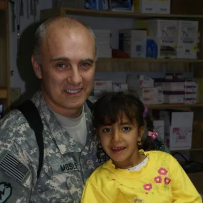 Dr. E. Wayne Mosley served seven tours in Afghanistan and Iraq as a combat physician with the U.S. Army. He's pictured here with a young patient in Mosul, Iraq. Photo Courtesy of Dr. E. Wayne Mosley