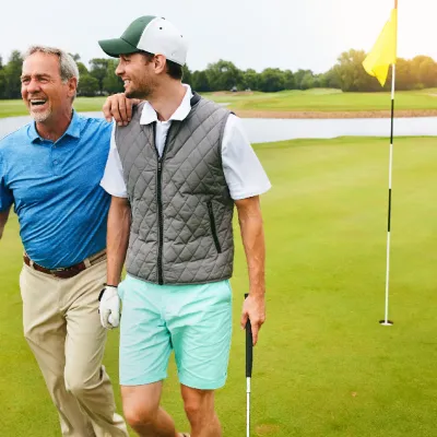 Two grown men walking away from a golf hole