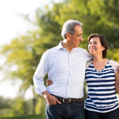 A mature couple walking while holding each other