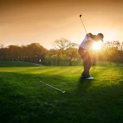 A golfer playing during sunrise