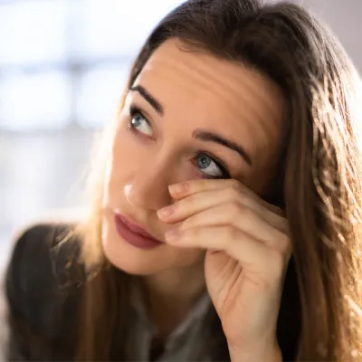 A woman rubs her eyes.