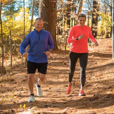 A Middle Aged Couple Goes For a Jog Through a Wooded Trail.