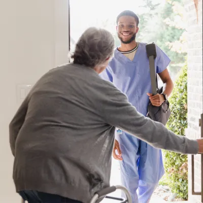 A Patient Opens Their Front Door to Allow a Therapist in Their Home