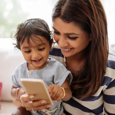 Mother and child using phone at home.