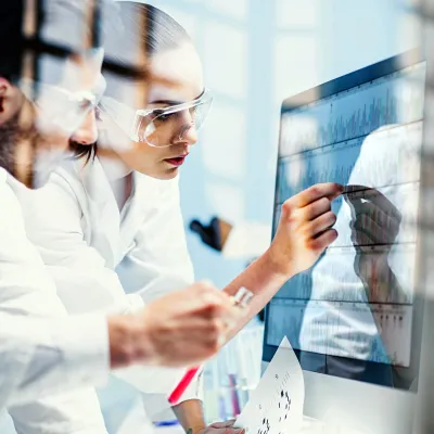 Two Physicians Look Over Test Results While in Scrubs