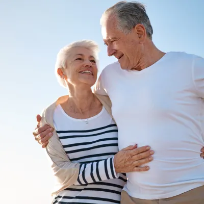 A couple walks on the beach after a successful hernia surgery.