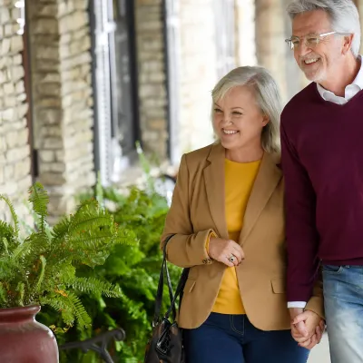 A couple of seniors holding hands while walking outdoors