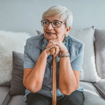 A woman sitting on her couch thinking.