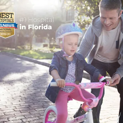 Father teaching his daughter to ride a bike