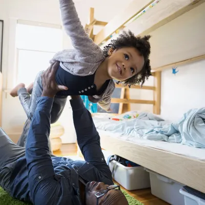 Child being held in the air with outstretched arms