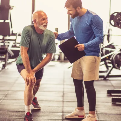 An older man works with a physical therapist.