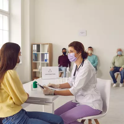 A nurse talking to a patient at a vaccine site