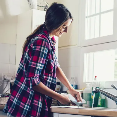 A happy woman doing the dishes.