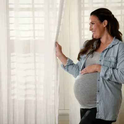 Pregnant woman standing near window