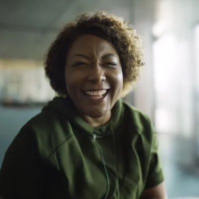 A smiling woman in a large empty room