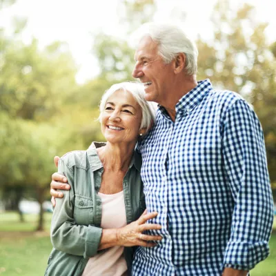 A Senior Couple Hugs in the Woods