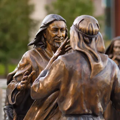 Statue of Jesus approaching a man to heal him.
