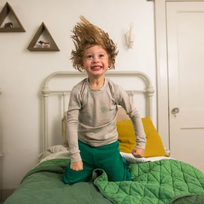 Little boy jumping on the bed.