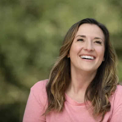 A smiling woman wearing a pink shirt.