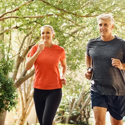 A Middle Aged Couple Jogging Through the Woods to Keep Fit