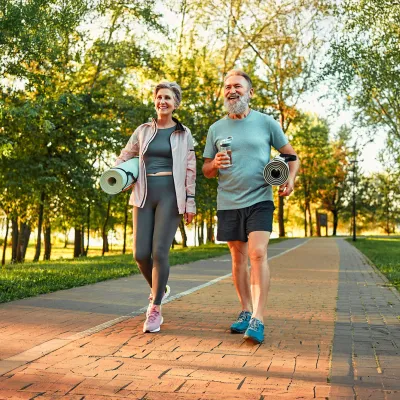 Senior Couple Walking and Talking Through a Park