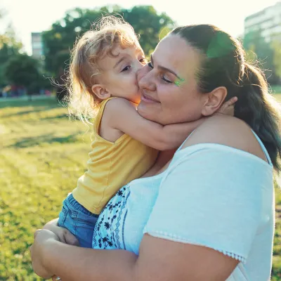 Mother and daughter embracing outdoors.