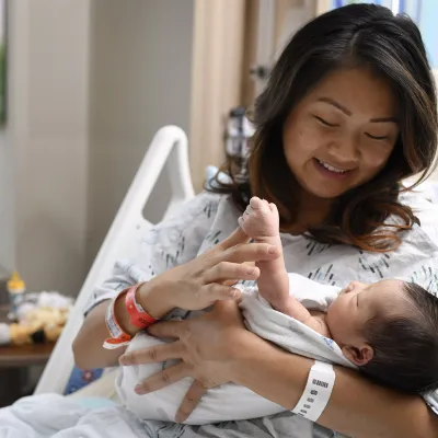 Mother holding her newborn baby in a hospital bed