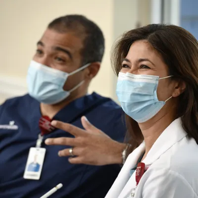 Two physicans wearing masks talking