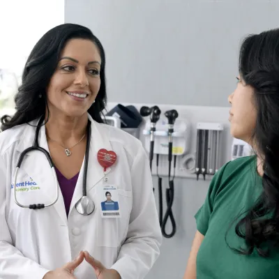 A Primary Care+ Physician Speaks to a Patient in an Exam Room 