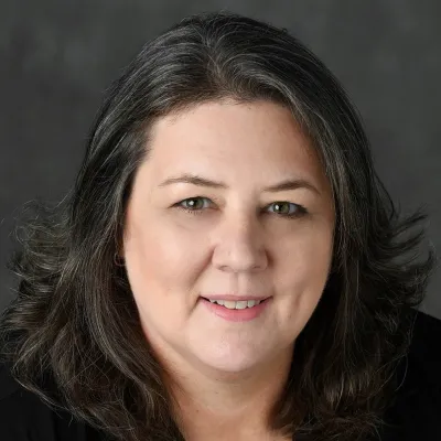 headshot of Ramona Reynolds, dressed in black in front of gray background
